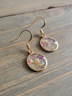 Rainbow mixed flowers dangling earrings with resin petite gold pendants of dried multicolored flowers. ♡ These earrings are handmade from the very first step. I personally collect and dry the natural elements, and create each beautifully preserved shape with resin formulas.  Be sure to check out the RED EARRINGS section at EarringsbyLCreations for all beautiful red colored earrings available! https://www.etsy.com/shop/EarringsByLCreations?section_id=28420977 Made with quality materials and alway Gold Earrings With Floral Print For Gift, Gold Floral Print Earrings As Gift, Gold Floral Print Earrings For Gift, Gold Dangle Earrings With Pressed Flowers, Gold Round Flower Earrings In Resin, Gold Resin Earrings With Birth Flower, Gold Resin Earrings With Birth Flower Detail, Pressed Flower Drop Earrings, Gold Flower Charm Earrings In Resin