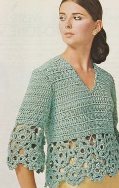 a woman wearing a green crochet top and yellow pants with her hands in her pockets