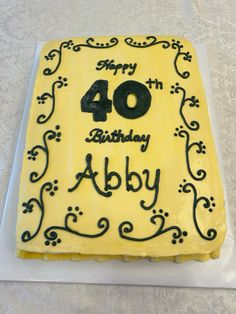 a birthday cake with the number forty in black and yellow frosting on it's side