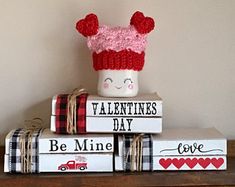 valentine's day books stacked on top of each other with a knitted hat