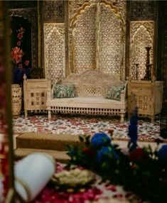 an elaborately decorated living room with flowers on the floor and furniture in front of it