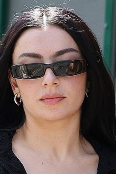 a woman wearing sunglasses and looking at the camera