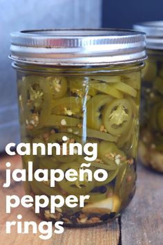 pickles in a jar on a wooden table next to another jar filled with pickles