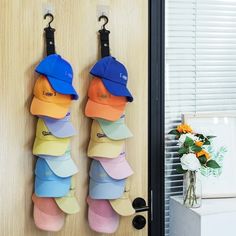 several hats hanging on hooks in front of a door