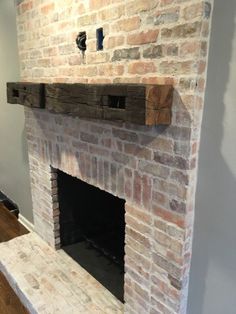 a brick fireplace in a living room with white walls