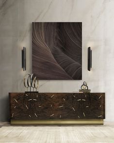 an abstract painting hangs on the wall next to a console