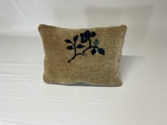 an embroidered pillow with blue flowers on it