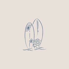 two surfboards sitting side by side in the ocean, one with a flower on it