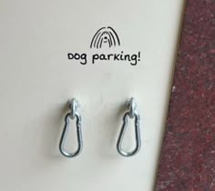 there are two pairs of hooks attached to a refrigerator door with the word dog parking written on it