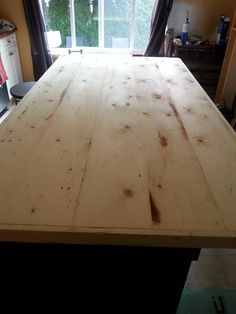 a wooden table sitting in front of a window