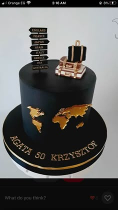 a black and gold birthday cake with the names of cities on it's side