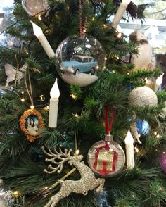 a christmas tree with ornaments on it and candles in the shape of deer, car ornament