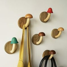 several mushrooms are mounted to the wall with hooks and bags hanging on it's sides