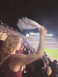 a woman in a red dress at a football game holding up a white frisbee