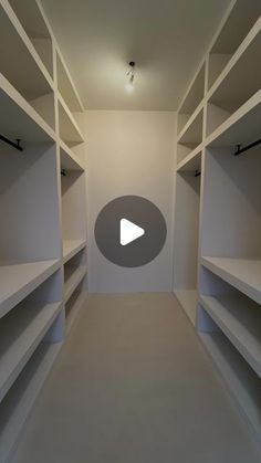 an empty walk in closet with white shelves