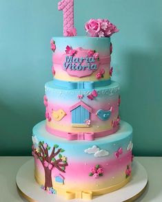 a three tiered cake decorated with pink and blue frosting