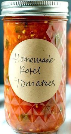 a jar filled with pickled tomatoes sitting on top of a table