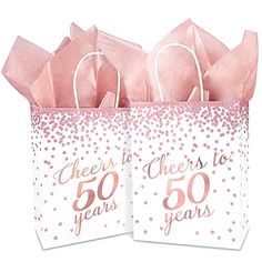 two pink and white paper bags with the words cheers to 50 years on them