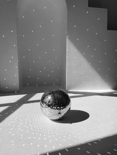 a shiny ball sitting on top of a white floor next to a wall covered in stars