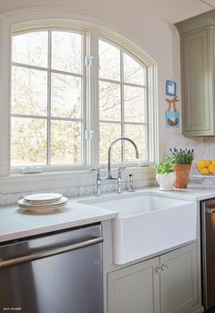 a kitchen with a sink, dishwasher and window