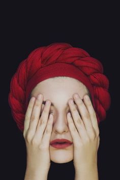 a woman with red hair covering her eyes