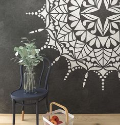 a room with a chair, vase and blackboard on the wall in front of it