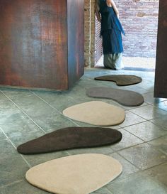 a woman is standing in the doorway with her back to the camera and several rugs on the floor