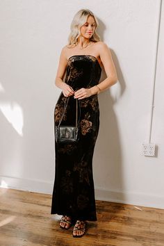 - Step into elegance with this stunning velvet maxi dress! Featuring a chic strapless cut and an enchanting moody floral print, it's perfect for any occasion. Pair it with your favorite accessories and step out in style, ready to turn heads wherever you go! - Unlined velvet material with a brown hued floral print - A straight, strapless cut neckline with an interior non-slip strip - An elastic strap across the back and a draped back detail - Side zip closure - A flattering silhouette that ends i Elegant Strapless Dress With Floral Print For Night Out, Elegant Strapless Floral Dress For Night Out, Elegant Floral Print Strapless Dress For Night Out, Black Velvet Maxi Dress For Party, Black Velvet Maxi Dress For Night Out, Black Velvet Maxi Dress For Formal Occasions, Strapless Floral Print Evening Maxi Dress, Black Velvet Evening Maxi Dress, Black Velvet Floral Dress