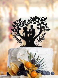 a wedding cake topper with an image of a bride and groom under a tree