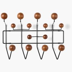 a metal rack with wooden balls hanging from it's sides on a white wall