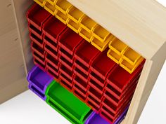 colorful bins are stacked on top of each other in a wooden cabinet with white background