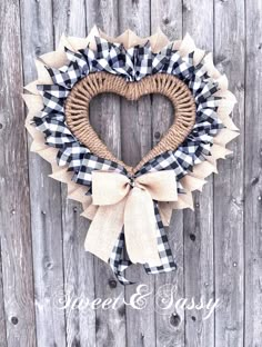 a heart shaped wreath hanging on the side of a wooden fence with burlocks