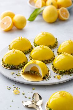 lemon meringue desserts on a plate with silverware and lemons in the background