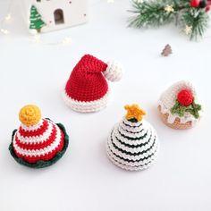 three crocheted christmas hats sitting next to each other on a white table top