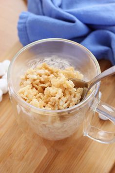 a glass bowl filled with cereal on top of a wooden table