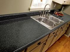 a kitchen with black counter tops and wooden floors