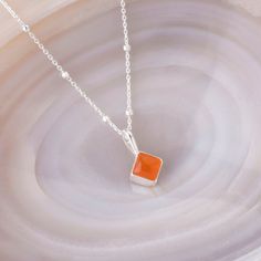 A perfect and unique birthstone gift for those born in July. The diamond-shaped cut Carnelian gemstone is handset into high-quality sterling silver with an 18" eco-silver satellite chain, creating a durable and long-lasting accessory. Each necklace is carefully crafted by skilled artisans with utmost care and attention to detail, making it a rare and beautiful piece of birthstone jewellery.  Carnelian: stimulate creativity | motivation | reduce fatigue We want your jewellery to stay in great con Sterling Silver Birthstone Necklace With Polished Finish, Sterling Silver Polished Birthstone Necklace For Gifts, Sterling Silver Polished Finish Birthstone Necklace For Gift, Sterling Silver Birthstone Necklace With Polished Finish As Gift, Silver Birthstone Necklace With Polished Finish As Gift, Sterling Silver Faceted Square Pendant Jewelry, Sterling Silver Faceted Square Pendant Necklace, Faceted Sterling Silver Square Pendant Jewelry, Orange Birthstone Necklace As Gift