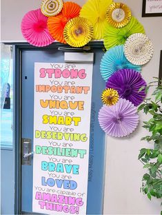 a classroom door decorated with colorful paper fans and saying about strong things on the front