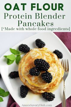 a white plate topped with pancakes covered in blackberries