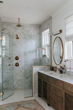 a bathroom with marble counter tops and gold fixtures on the shower wall, along with two sinks