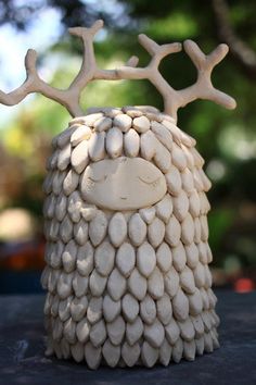 a white ceramic animal with antlers on it's head