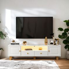 a flat screen tv mounted to the side of a white entertainment center in a living room