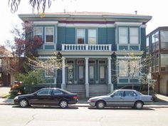 two cars parked in front of a blue house