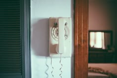 an old fashioned phone is hanging on the wall