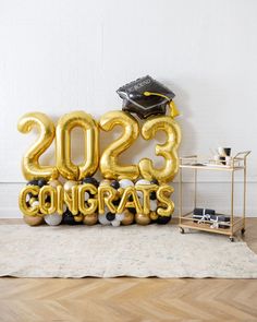 a graduation balloon with the number twenty two and balloons in the shape of letters that read 205 congrats