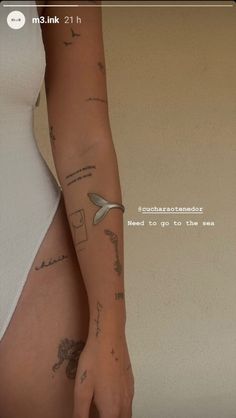 a woman's arm with tattoos on it and the words, i need to go to the sea