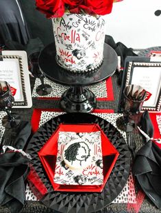 a black and red table setting with roses