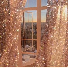 an open window with sparkling curtains in front of it