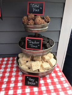 three tiered trays filled with treats on top of a red and white checkered table