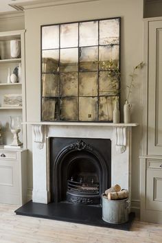 a living room with a fire place in the middle and white cabinets on either side